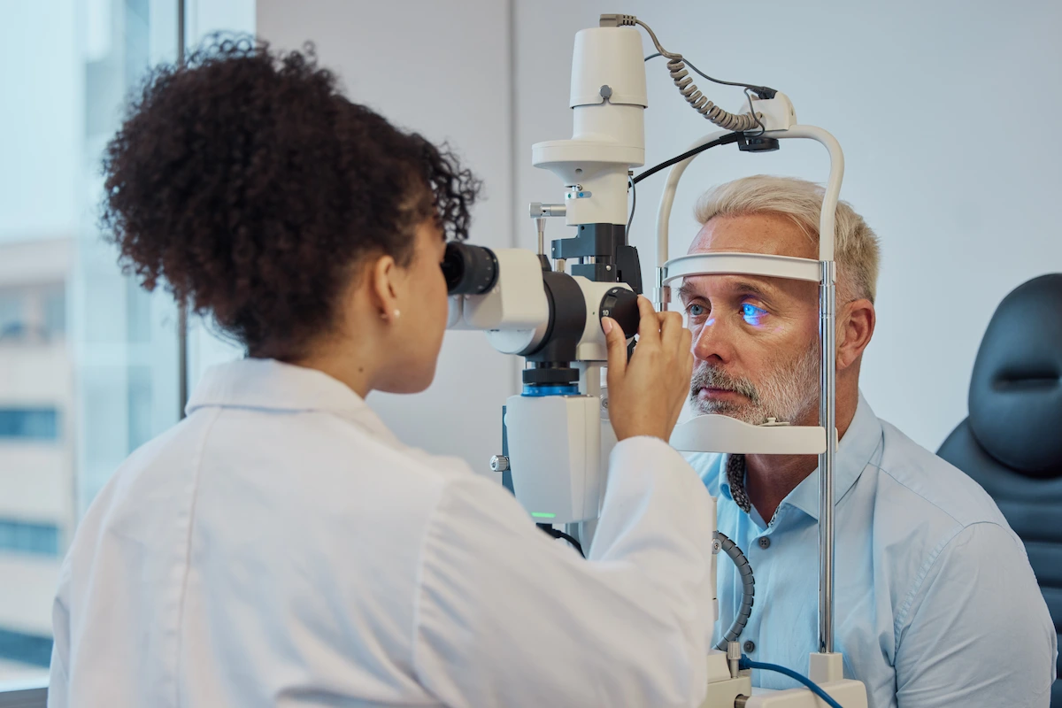 optometrist performing eye test on patient during routine exam